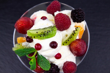 Lunch with dessert on the street. Sweet dessert on a black stone background. Berry dessert. Refreshing ice cream. Dessert with fresh raspberries
