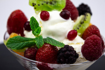 Sweet dessert on a white background. Berry dessert. Refreshing ice cream. Dessert with fresh berries and mint. Macro.