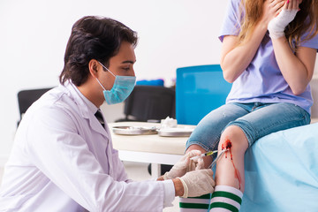 Leg injured young woman visiting male doctor 