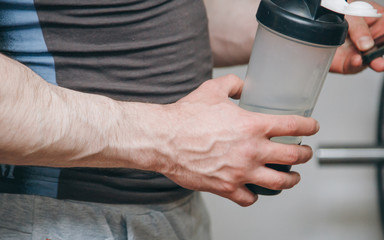 athlete with big hands resting between exercises in the training center. training tools in the gym close-up