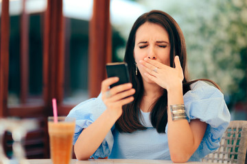 Sleepy Woman Being Bored with Her Smartphone in a Restaurant