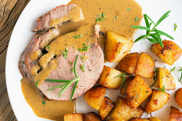 marinated in lemon juice, white wine, and herbs lamb baked with potatoes and served with gravy and fresh herbs