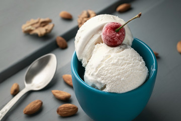 Ice cream balls in a cup on a wooden table with nuts
