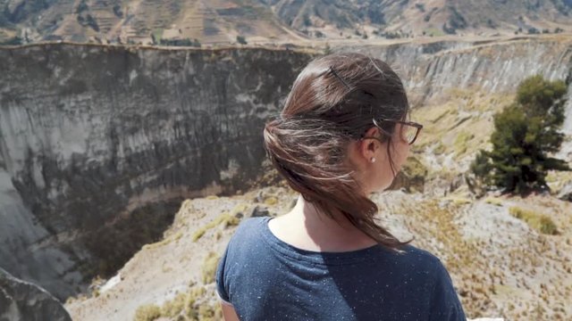 Tourist girl looking over canyon in Ecuador.