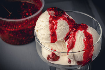 Close up ice cream balls with raspberry jam on a wooden table