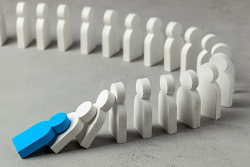 Domino effect in business. One businessman leader falls and brings down other figures of employees....
