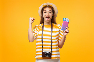 Good-looking European girl with retro camera on neck isolated on background holding airticket and shouting with joy