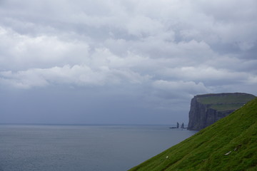 Faeroe Islands with beautiful nature, green grasslands, sea, rocks and breathtaking landscape