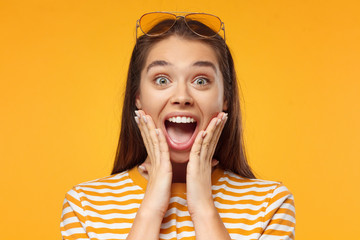 Shocked young girl, looking at camera with mouth wide open. Oh my god! Wow!