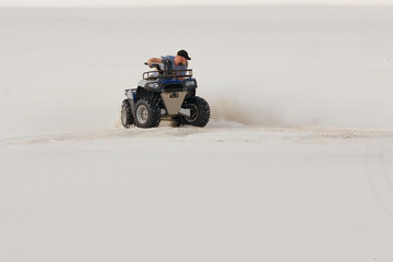 The guy and the girl ride a quad bike in the desert, having fun and enjoying, a couple of lovers
