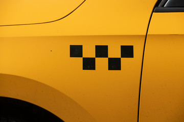 Taxi sign in the form of five black cubes on a yellow car