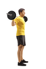 Young man standing and lifting weights on shoulders