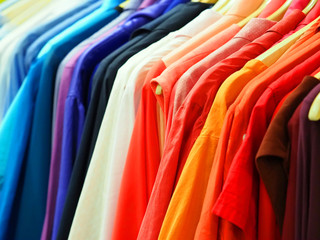 Hangers with bright clothes. Shopping concept, clothes background, close-up