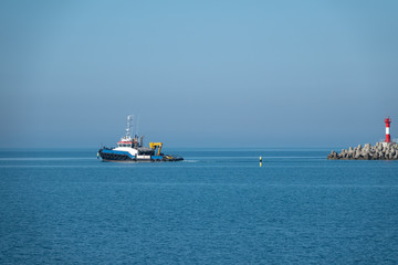 Fototapeta premium The sea tug comes out of the harbor