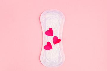 Red hearts and daily, menstrual woman pad for hygiene or blood period on pink background.