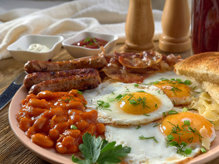 Fried eggs,stewed beans,delicious sausages and toast.