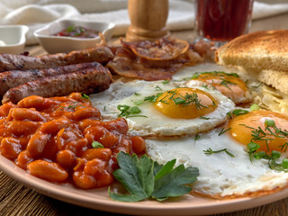 Fried eggs,stewed beans,delicious sausages and toast.