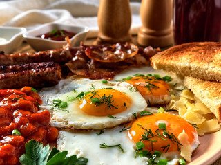 Fried eggs,stewed beans,delicious sausages and toast.