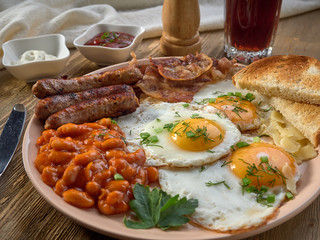 Fried eggs,stewed beans,delicious sausages and toast.