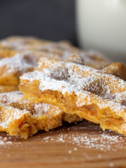 crushed carrot waffle dusted with icing sugar on a wooden plate