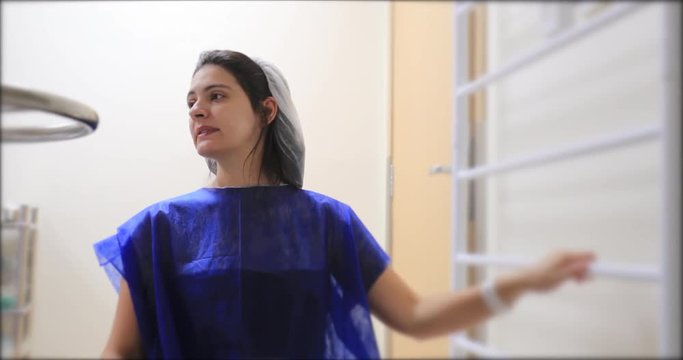 Pregnant woman bouncing on pilates ball at hospital clinic, preparing for labor, early stages of contractions