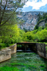 South of France, view on small Provencal town of poet Petrarch Fontaine-de-vaucluse with emerald green waters of Sorgue river