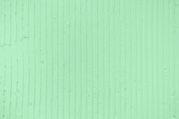 Naklejka premium Closeup of the wall with a decorativetrendy colored mint plaster vertical lines and stripes. Textured concrete wall with as a texture or background. Repair, design concept.