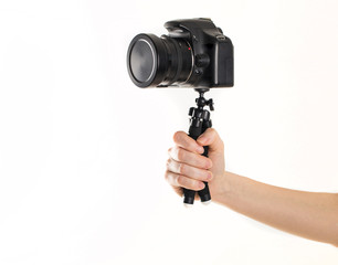 Woman hand and Black DSLR Camera on tripod isolated on white background