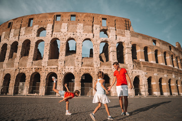 Happy family in Europe. Parents and kids in Rome over Coliseum background