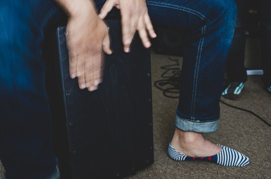 Cajon - Peruvian percussion instrument - being played by a man - hands in motion. 