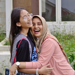 mother hug her teenage daughter and both laughing