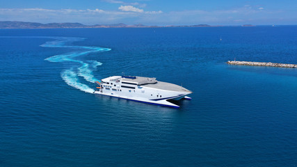 Aerial drone top view photo of high speed passenger ferry arriving at port of Mykonos island,...