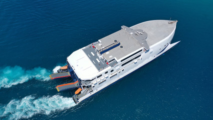 Aerial drone top view photo of high speed passenger ferry arriving at port of Mykonos island,...