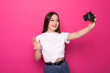 Young beautiful Asian woman blogger recording tutorial to share on social media isolated on pink...