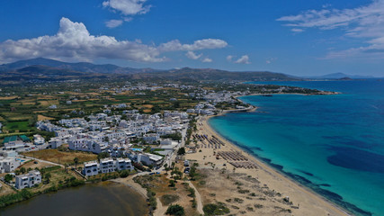 Fototapeta na wymiar Aerial drone top view photo of breathtaking turquoise sandy beach of Plaka with sun beds and umbrellas, Naxos island, Cyclades, Greece