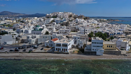 Aerial drone photo of iconic chora, main town of Naxos island featuring beautiful uphill castle views to the Aegean deep blue sea and Temple of Apollon at the background, Cyclades, Greece