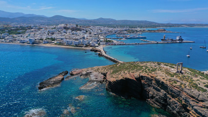 Aerial drone panoramic view of iconic and unique Temple of Apollon or Portara (Gate) with breathtaking views to port - town and castle of Naxos island and the Aegean blue sea, Cyclades, Greece - obrazy, fototapety, plakaty