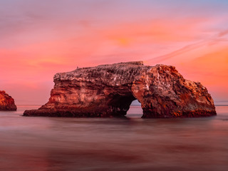 Beautiful rock arch against the colorful sunset sky