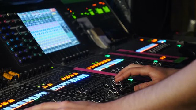Male dj adjusting controls at mixing console in nightclub. DJ mixer player. DJ at sound console. shot of professional musician hands, people create music on mixer with the help of sliders. hd