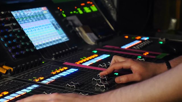 Close up of talanted male dj controling music on mixing console in nightclub. DJ mixer player. DJ at sound console. shot of professional musician hands, people create music on the mixer with the help