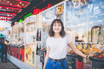 Beautiful asian girl in an amusement park, smiling