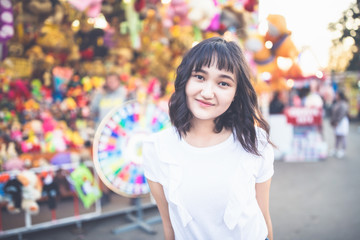 Naklejka premium Beautiful asian girl in an amusement park, smiling