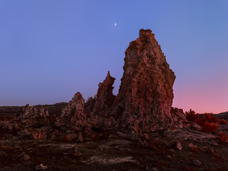 Unearthly scenery with bizarre rock formations and crescent moon