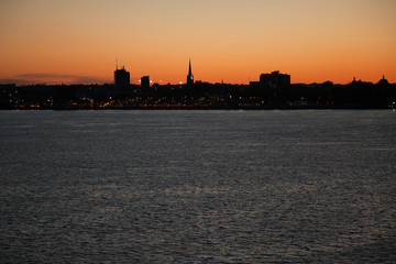 Fototapeta premium City landscape by the river at sunset