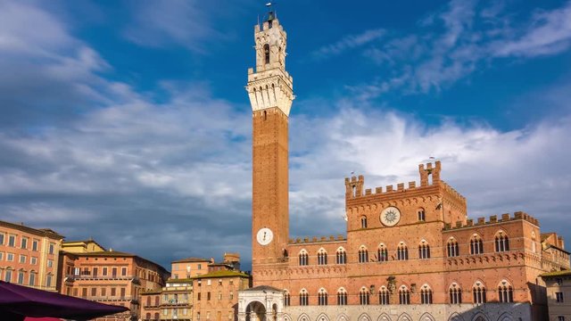 Siena, Tuscany, Italy. Piazza del Campo with the Palazzo Pubblico with its tall Torre del Mangia at sunset. Time lapse. Zoom effect