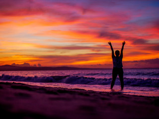 Fototapeta premium Silhouette of a woman on the beach at sunset