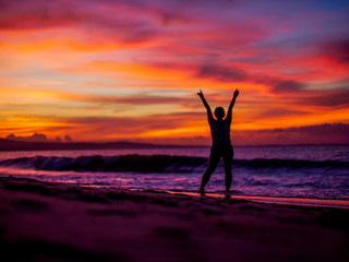 Silhouette of a woman on the beach at sunset