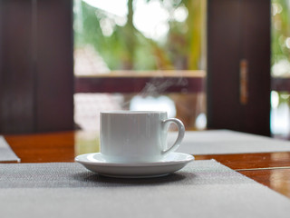 Cup of coffee on the table against the window