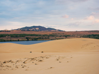 sand dunes, mountains and clouds in the sky