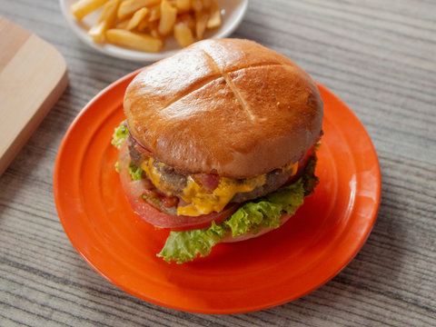 Half Pound Bacon Hamburger And Classic Yellow American Cheese In A Toasted Bun With A Side Of French Fries